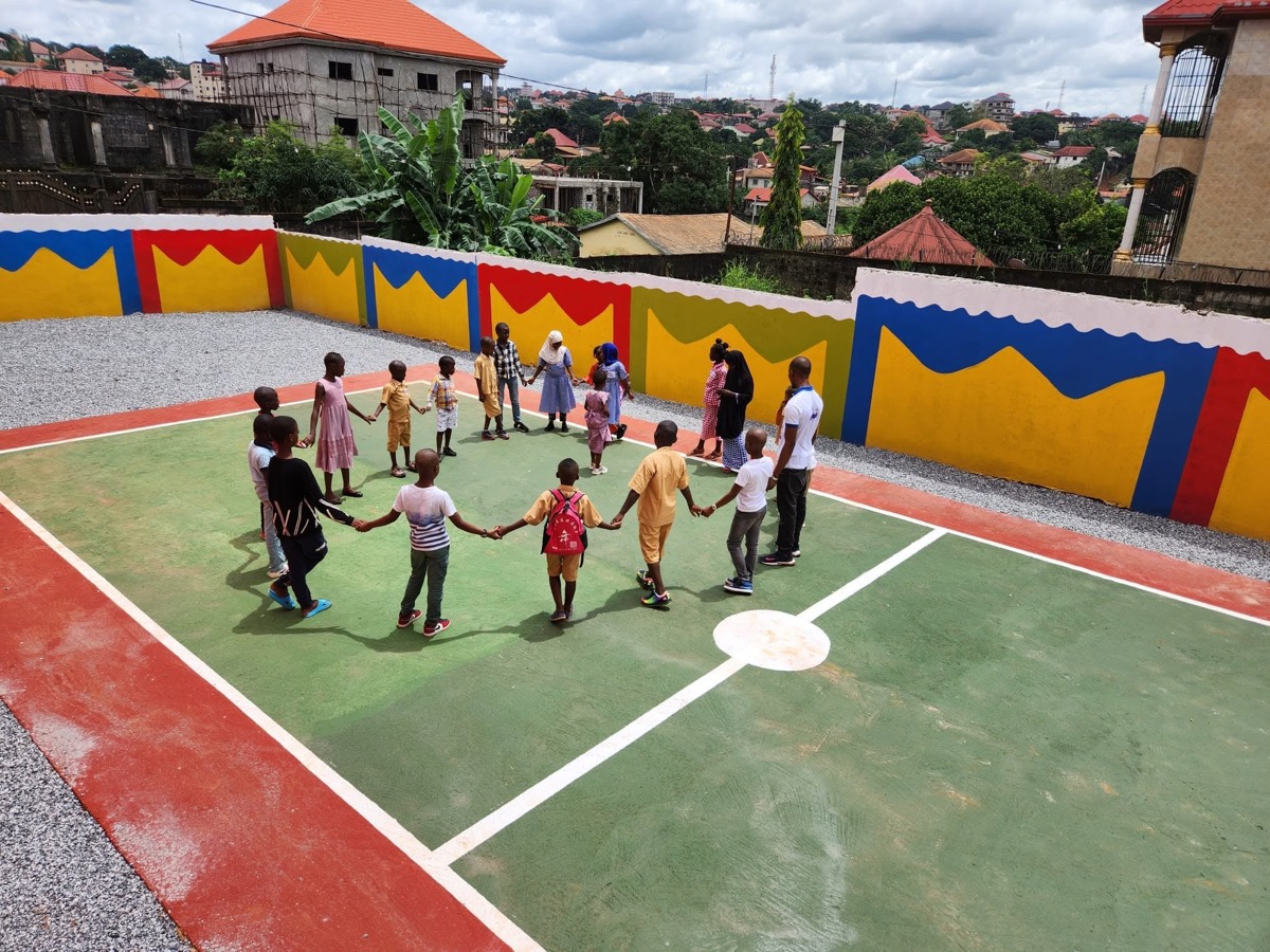Cour de récréation avec activité scolaire encadrée.